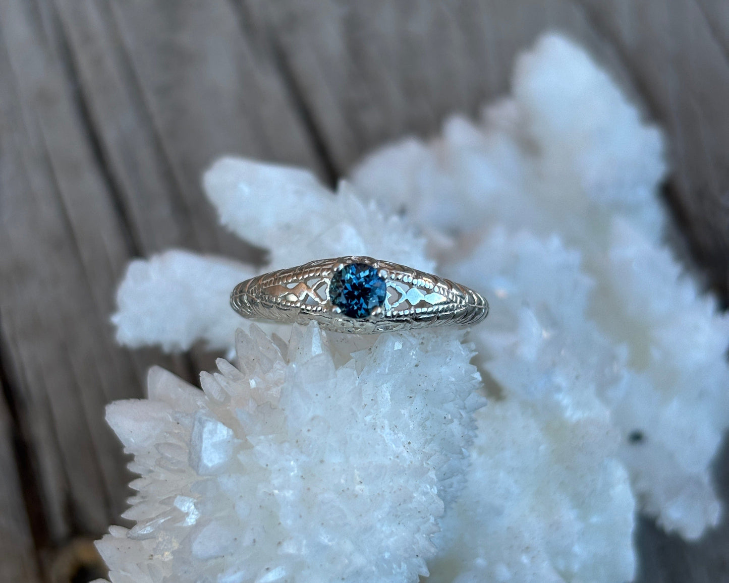 Silver ring with a blue sapphire on a piece of white coral.