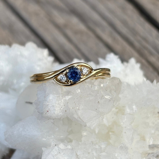 Gold ring with a blue Yogo sapphire and 2 diamond accents