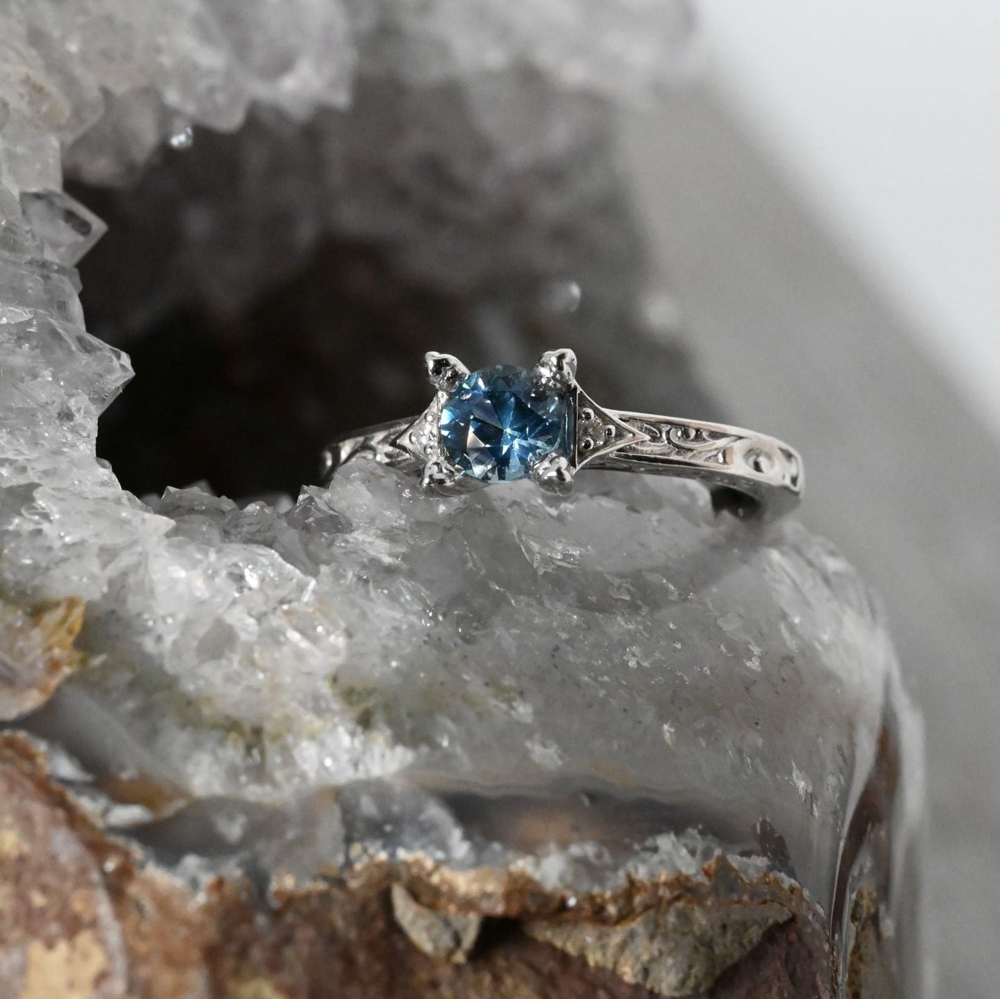blue Montana sapphire in art-deco-white gold ring with small diamond accents