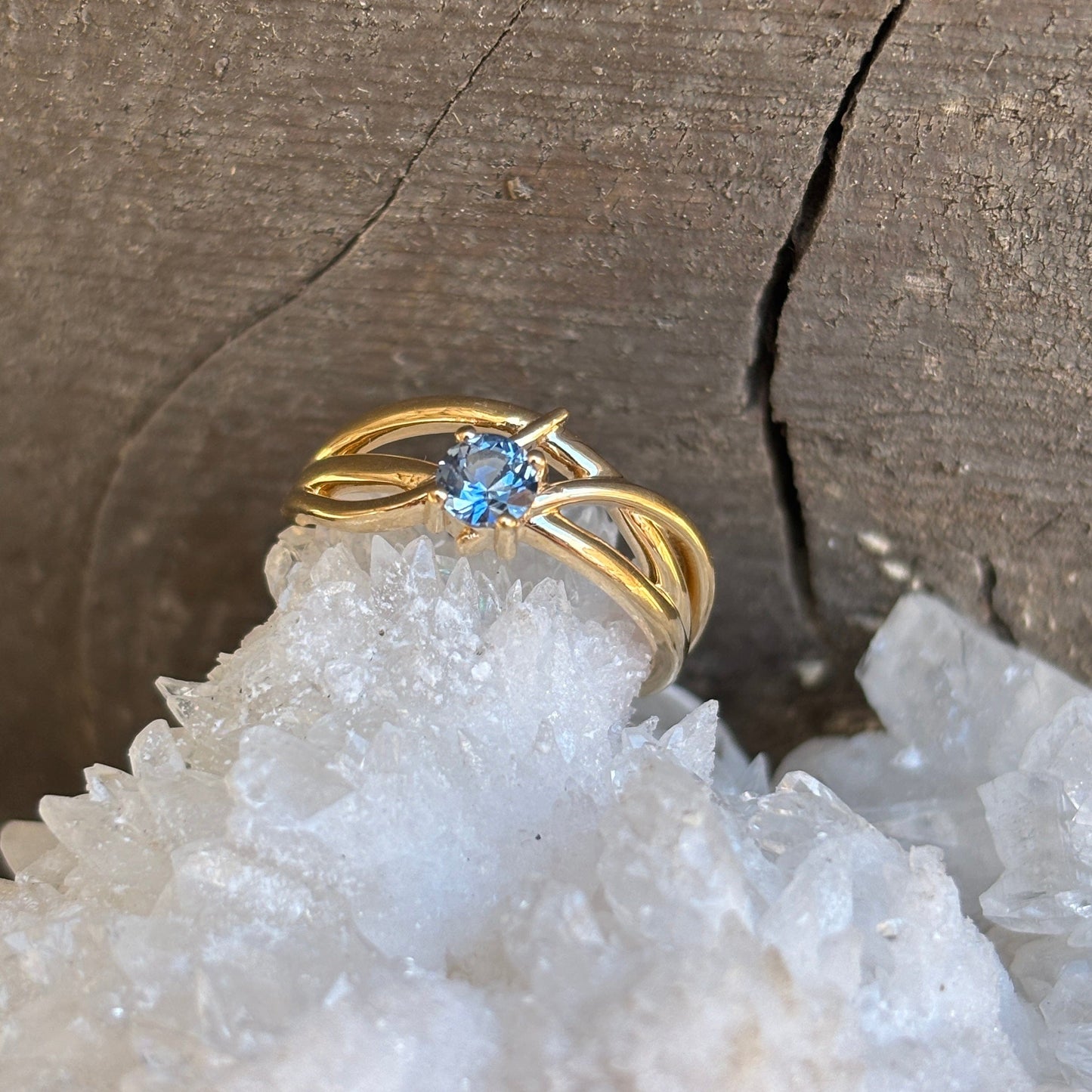 Gold ring with crossing lines set with blue Montana sapphire