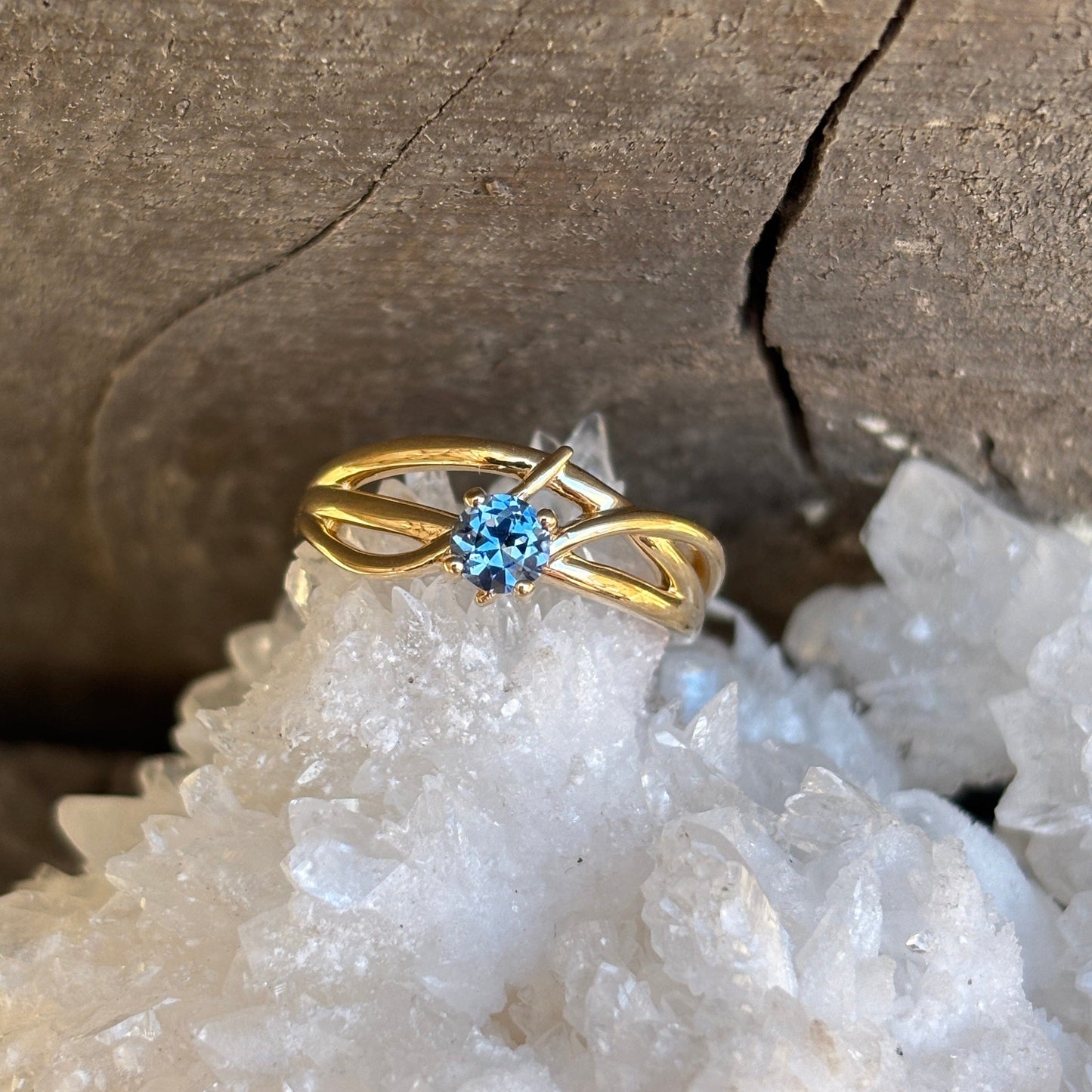 Gold ring in criss cross style with blue Montana sapphire 