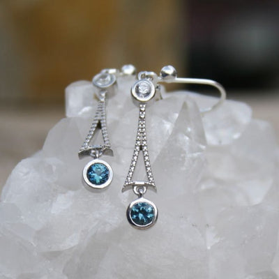 Silver drop earrings with 4mm round blue Montana sapphires and smaller, 3mm white sapphires above.  Sterling textured flared connectors bring it together. 