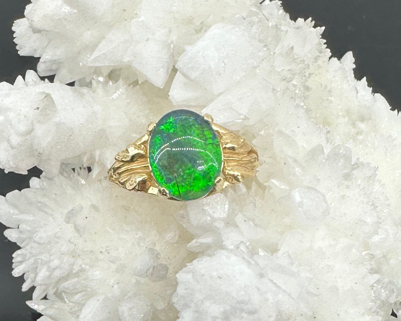 Gold ring with an Idaho opal on a stone background