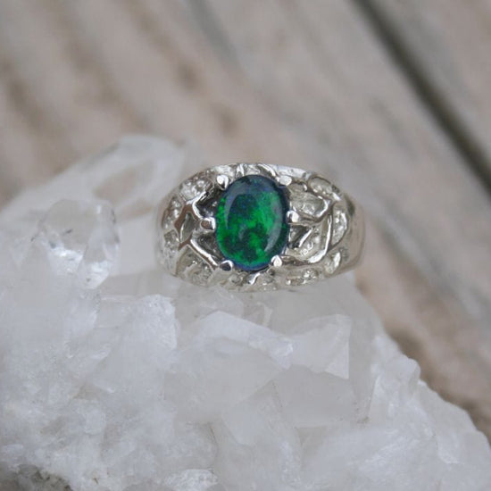 Silver ring with Idaho opal gemstone on a white crystal background