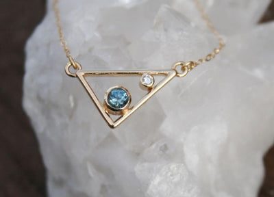 Gold triangle pendant necklace with blue gemstone