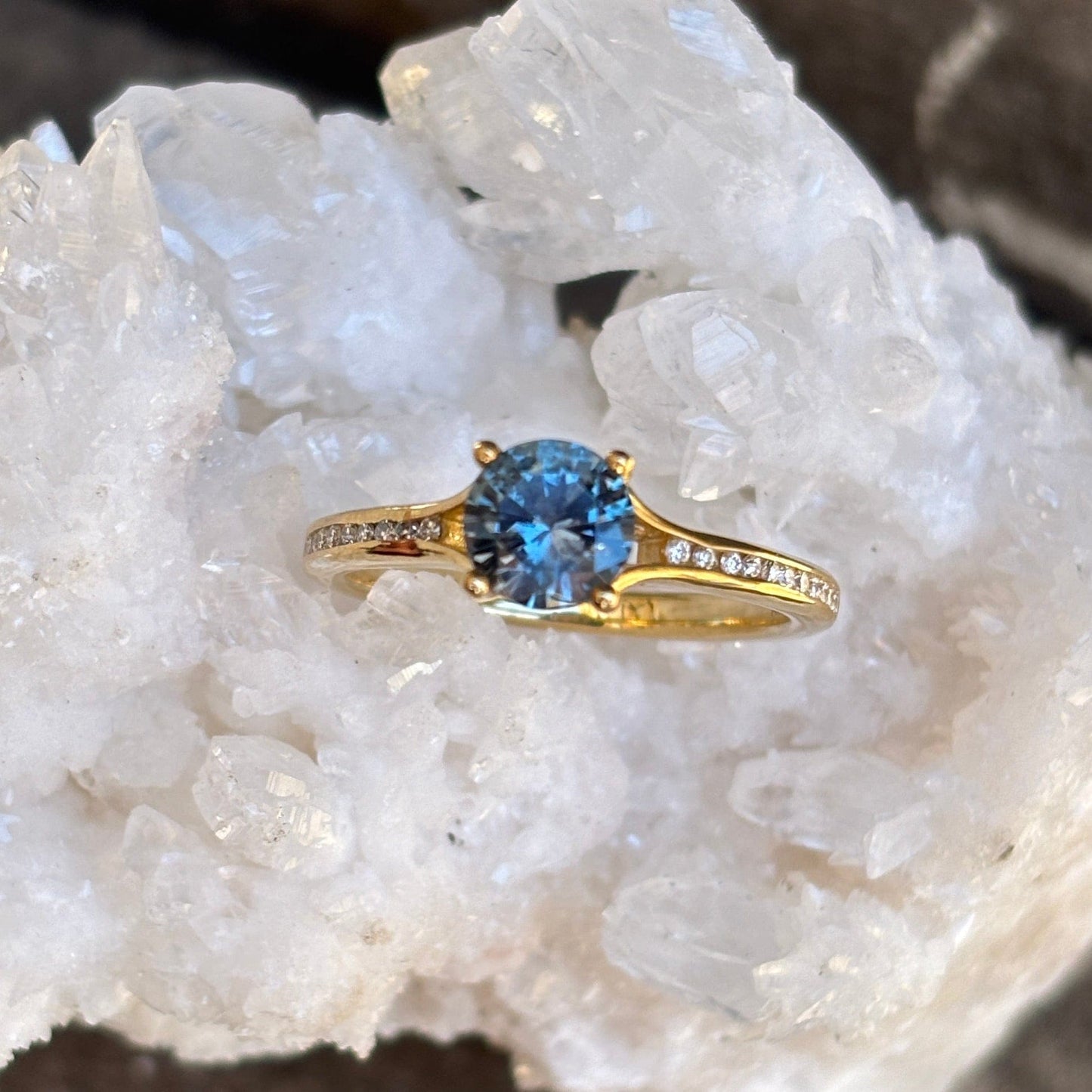 Gold ring with a blue sapphire and diamond accented band. 