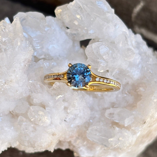 Gold ring with a blue sapphire and diamond accented band. 