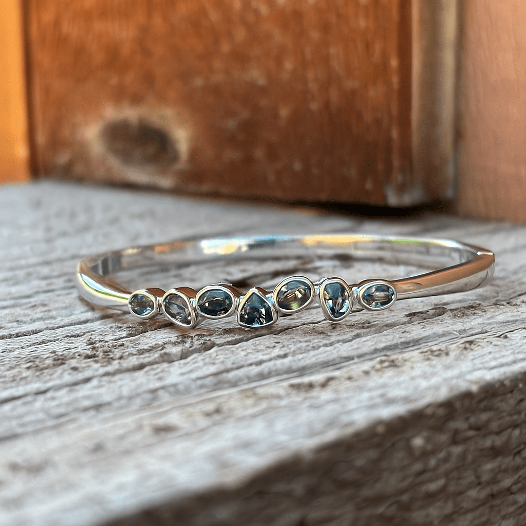 Silver bracelet with seven multi shaped sapphires in a sterling hinged bracelet