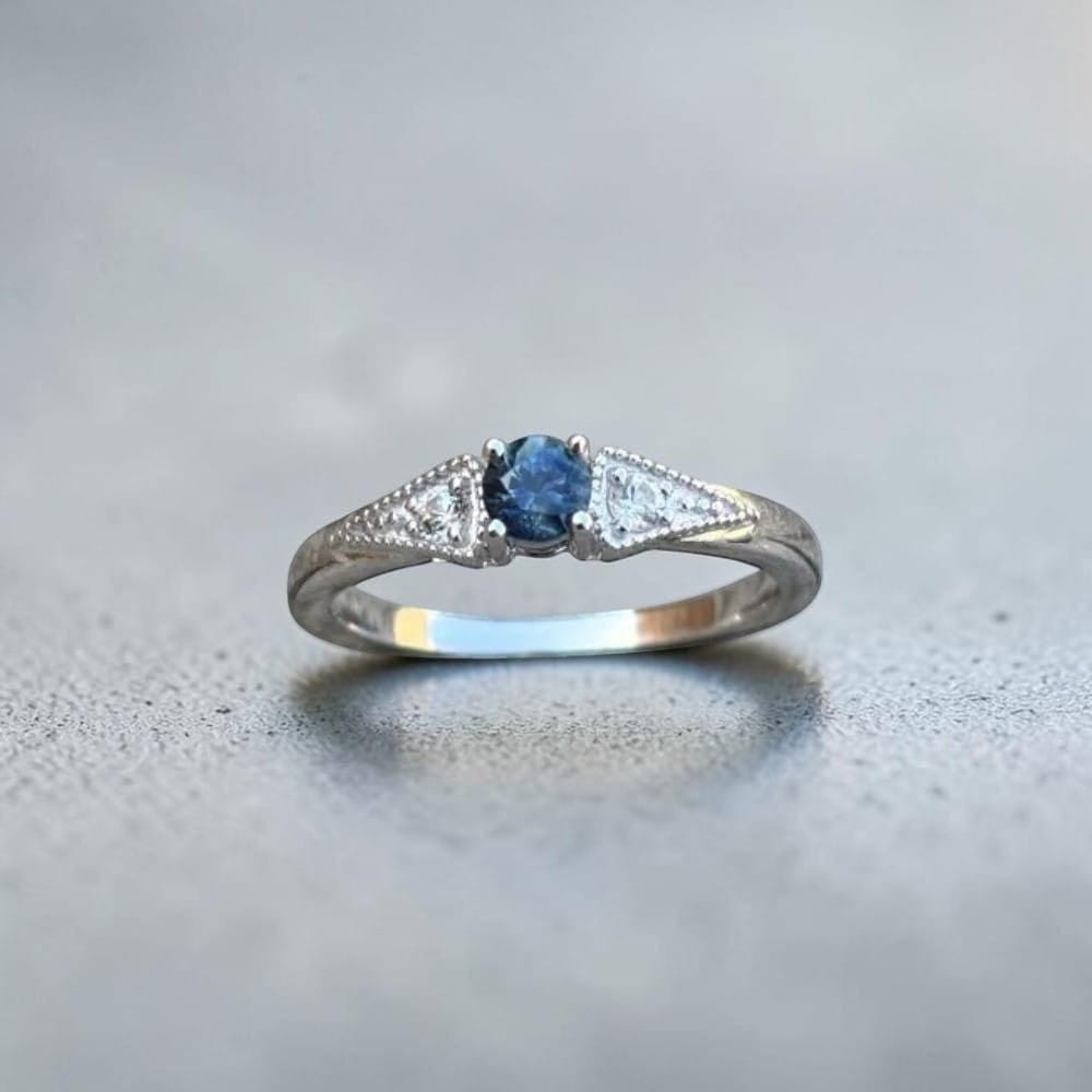 Antique inspired 3 stone ring set in sterling silver then rhodium plated for a clean, bright finish.