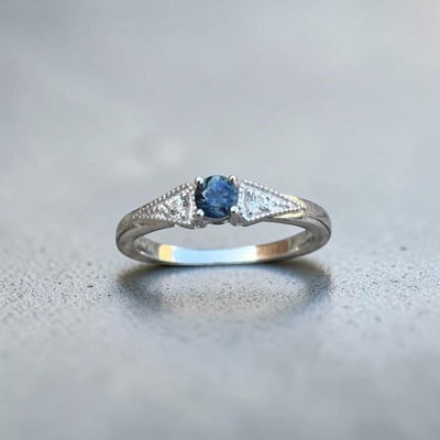 Antique inspired 3 stone ring set in sterling silver then rhodium plated for a clean, bright finish.