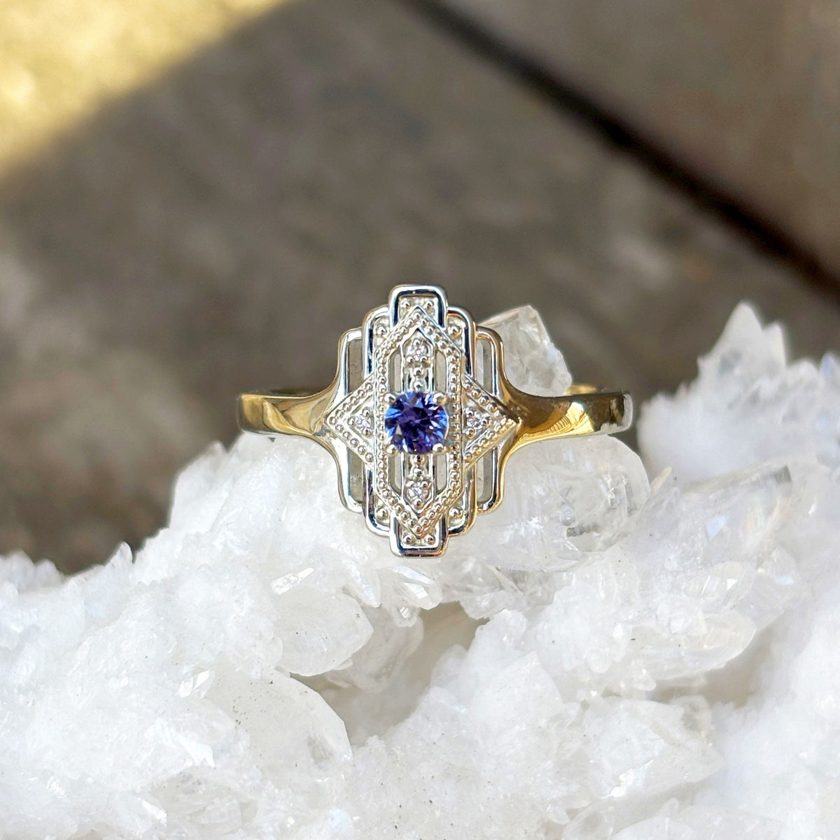 Art-deco style white gold ring with a purple Yogo sapphire in the center and diamond accents