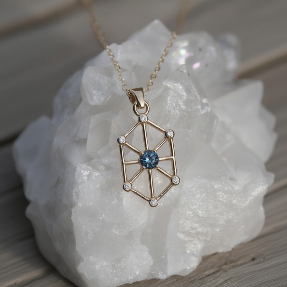 14k yellow gold art-deco inspired pendant with a Montana sapphire as the center and 6 small natural diamond accents