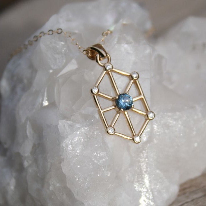 Gold pendant necklace with blue Montana sapphire on white stone