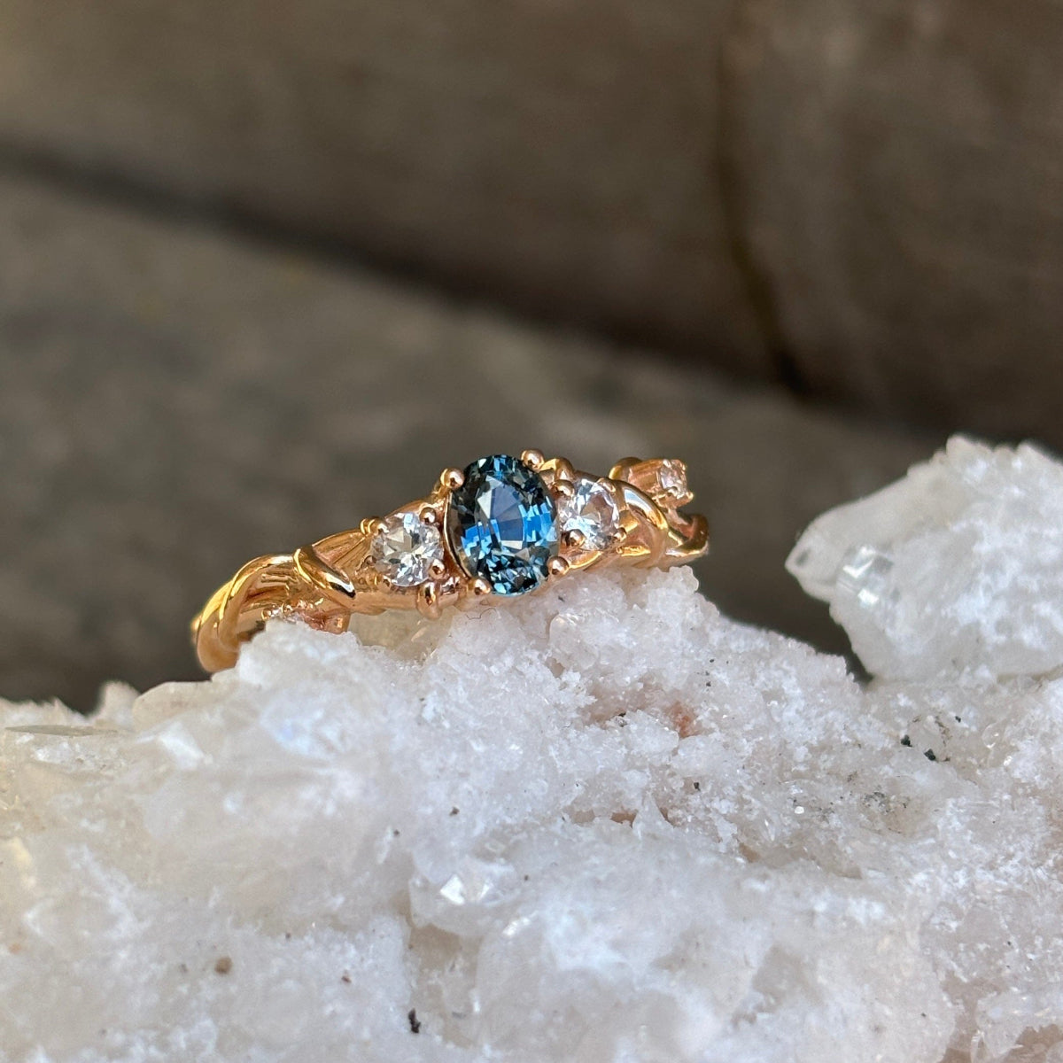 Blue sapphire ring with diamond accents in a barbed-wire inspired band created in rose gold. 