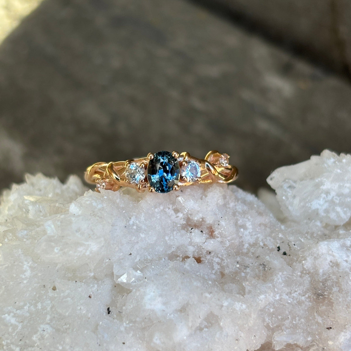 Rose Gold ring with a blue sapphire accented with diamonds. 