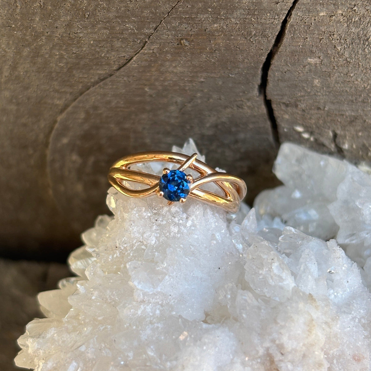 gold criss-cross style ring with blue Montana sapphire