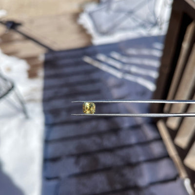 Yellow gemstone held by tweezers, croc_1709749675185