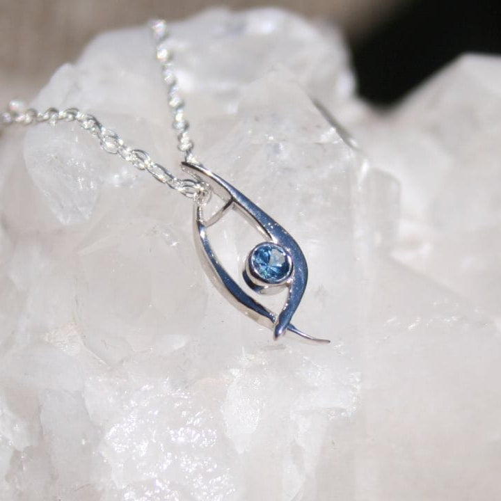 Silver pendant necklace with blue gem on quartz crystal 