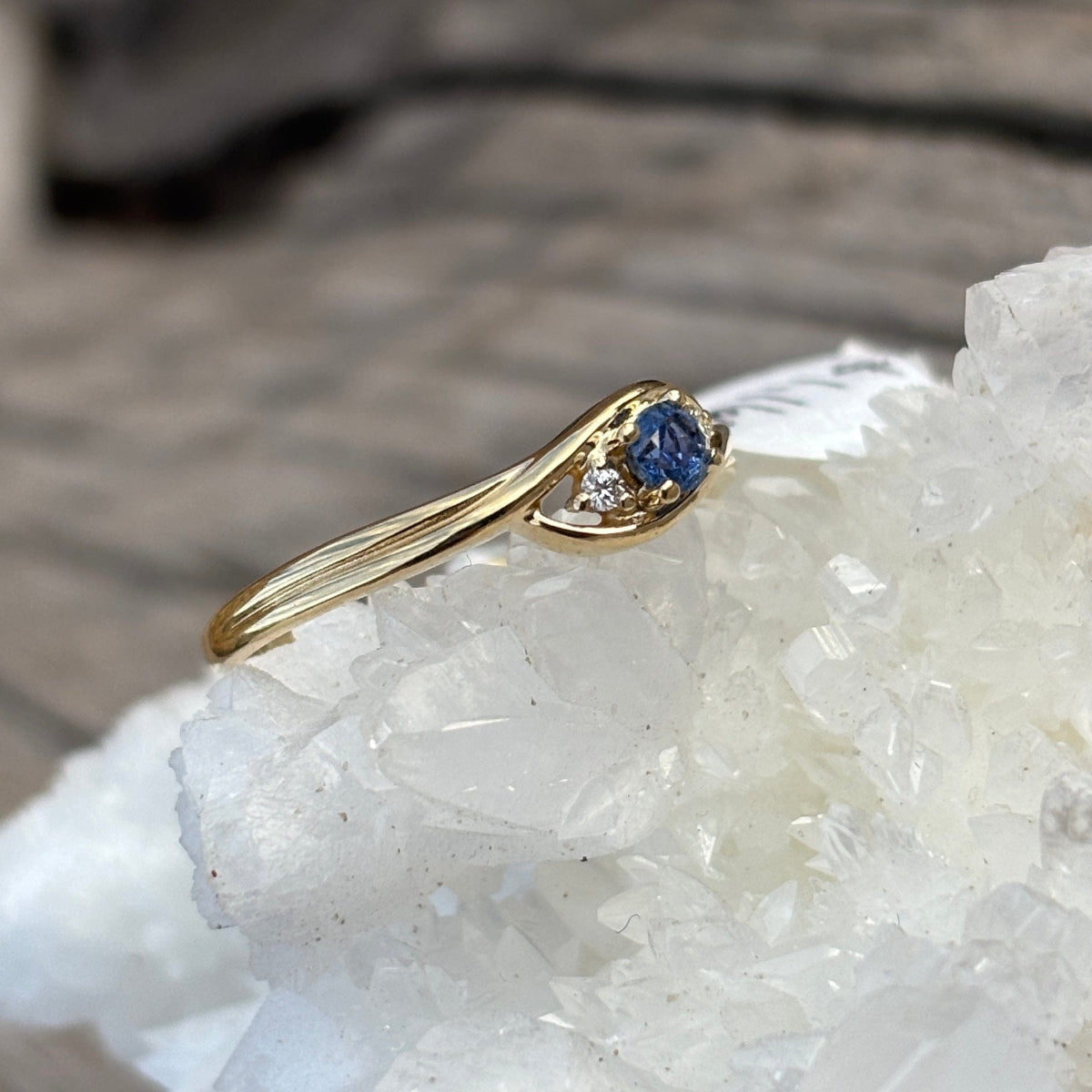 Yellow gold ring with dainty round Yogo blue sapphire center and 2 small diamonds

