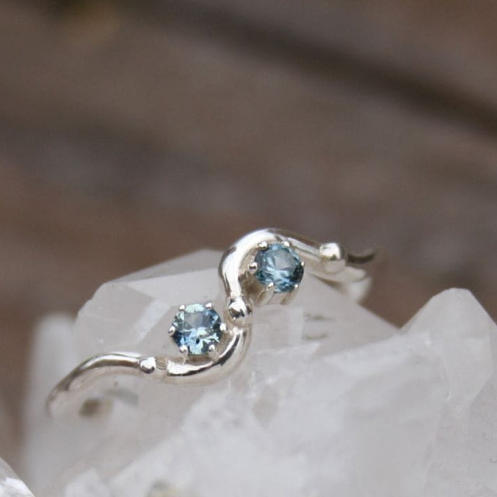 Two 3mm sapphires set on a wavy beaded band