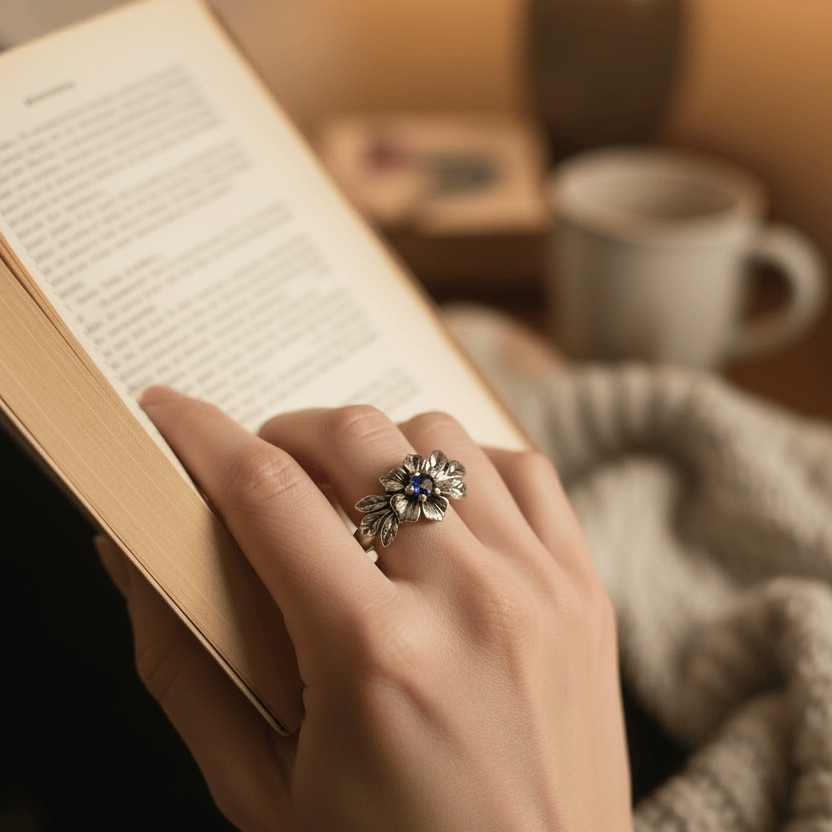 A silver ring with a blue Montana sapphire set in a dainty floral design ring. 