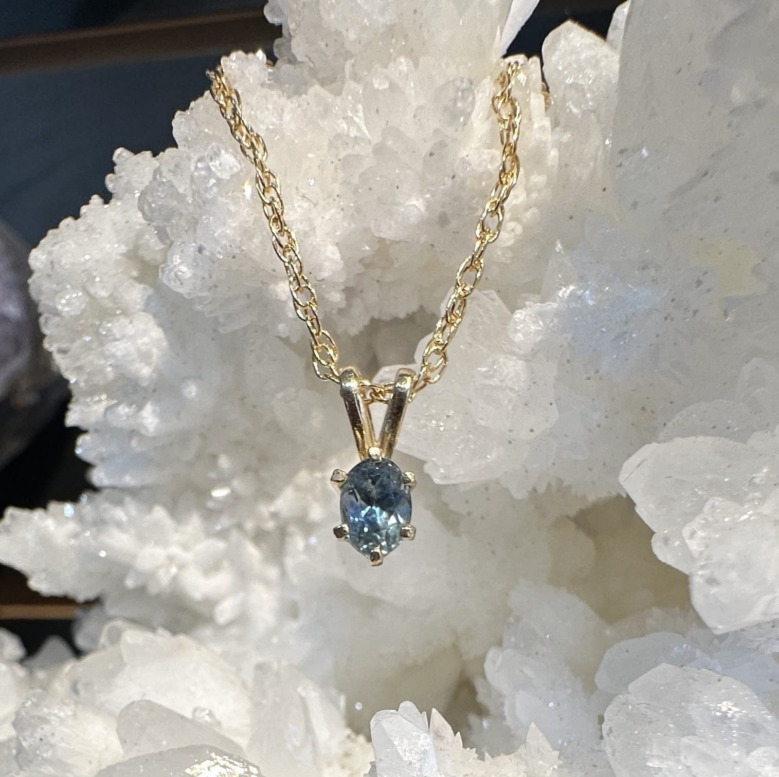 Montana Gems and Sapphire Jewelry icy blue Montana sapphire pendant in 14k yellow gold with a six-prong setting.