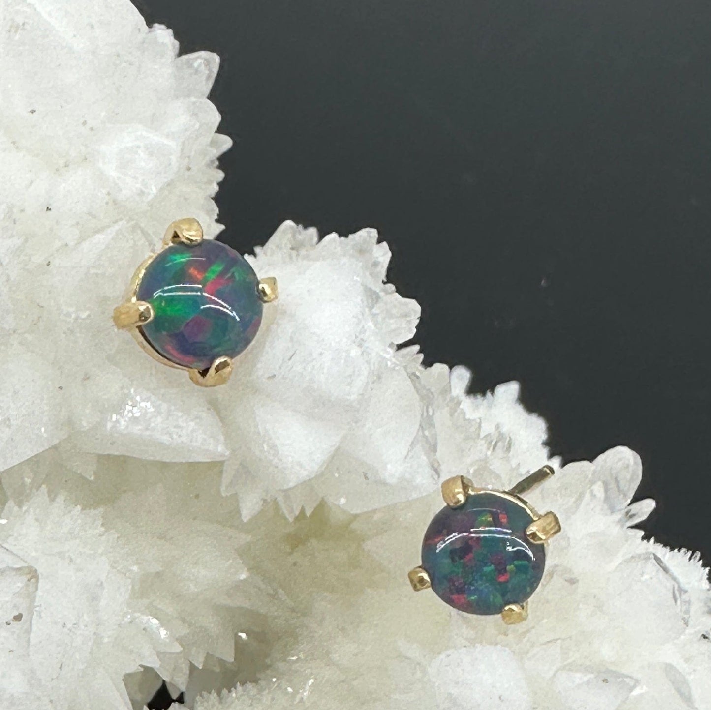 Opal stud earrings on a white crystal background