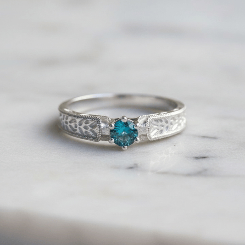 A silver ring with an dainty herringbone texture with a pretty Montana sapphire center