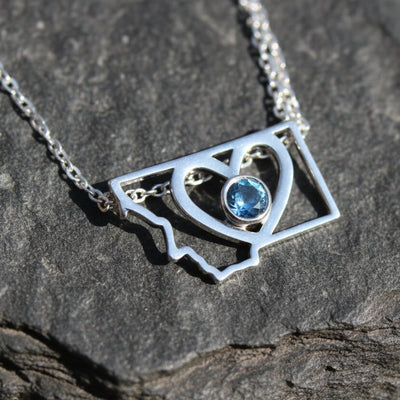 Montana state necklace with a heart in the center and a bezel set Montana sapphire in the very center