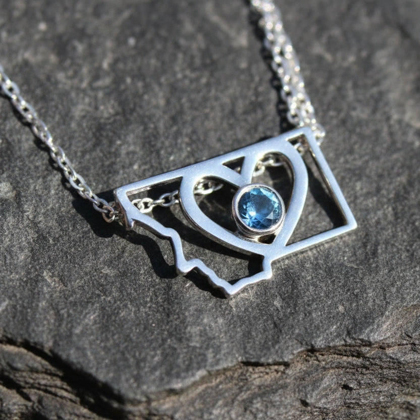 Montana state necklace with a heart in the center and a bezel set Montana sapphire in the very center