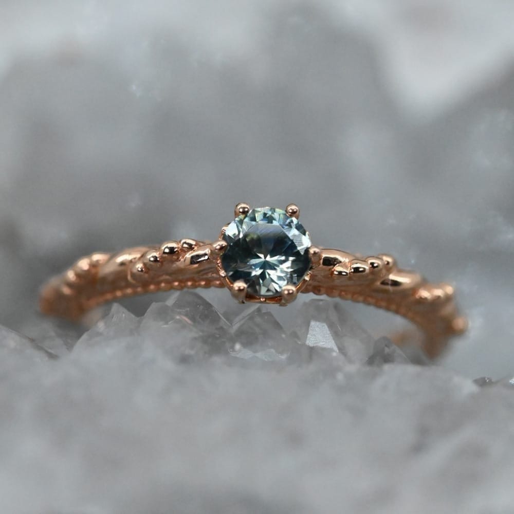 Montana Gems and Sapphire Jewelry 14k rose gold ring with a round Montana sapphire and a textured beaded band.