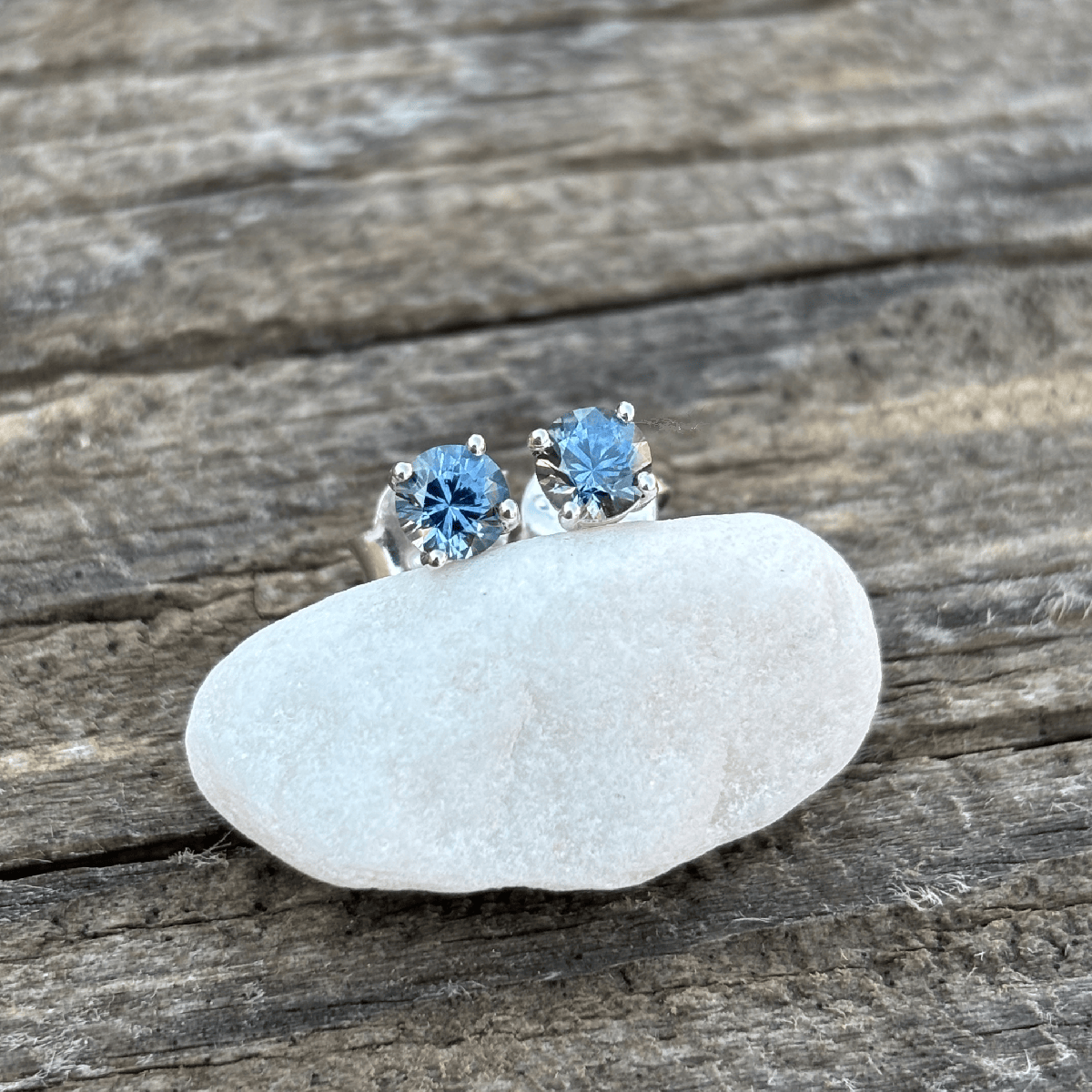 A pair of silver stud earrings with round blue Montana sapphires. Classic 4 prong settings with butterfly style backs.