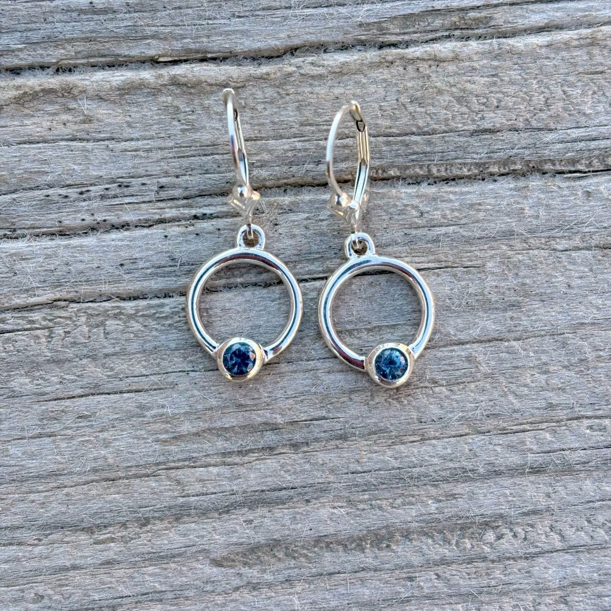 Silver hoop earrings with blue bezel set Montana sapphire