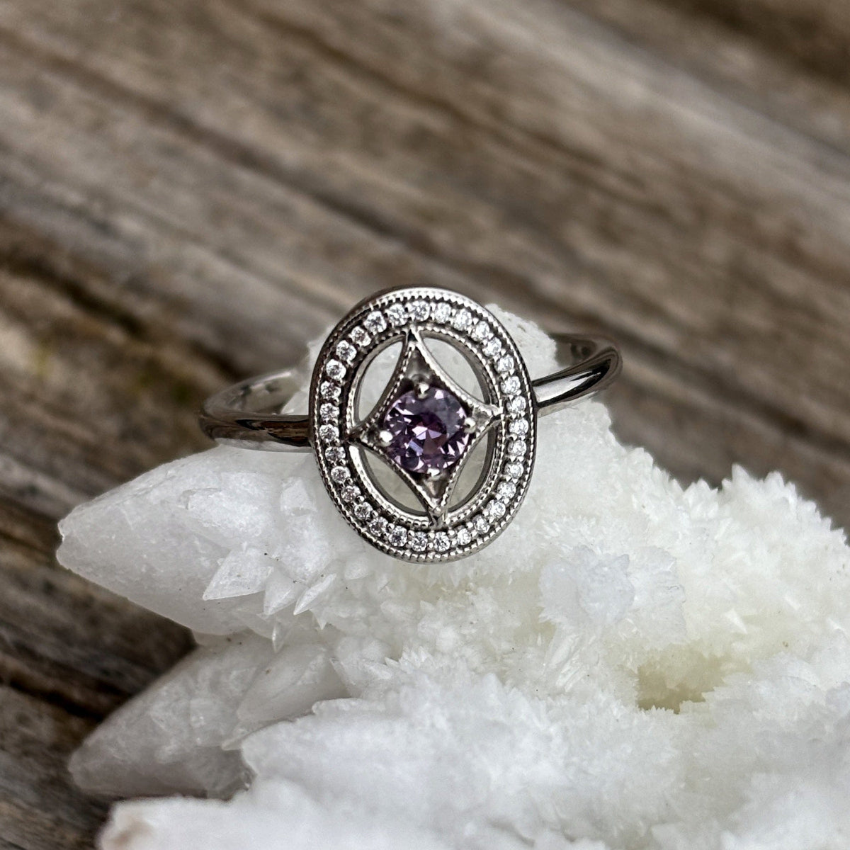 White gold ring with unique halo and a purple pink Montana sapphire  and diamond accents