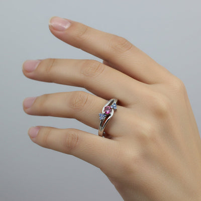 White gold ring with pink sapphire center and 6 tiny blue yogo sapphire accents. 