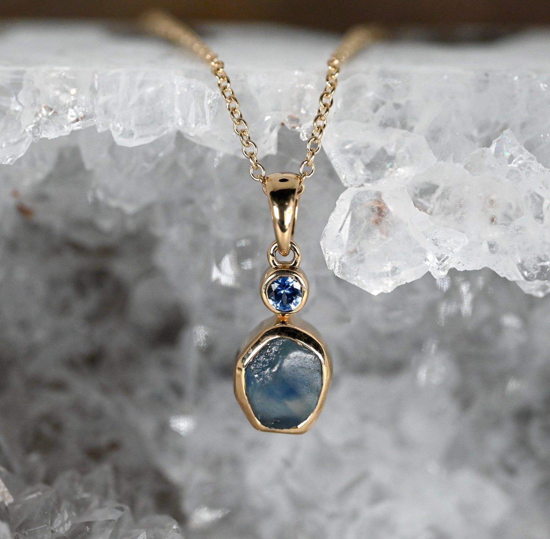 Heated Montana sapphire set with a 3mm Yogo sapphire in 14k rich yellow gold
