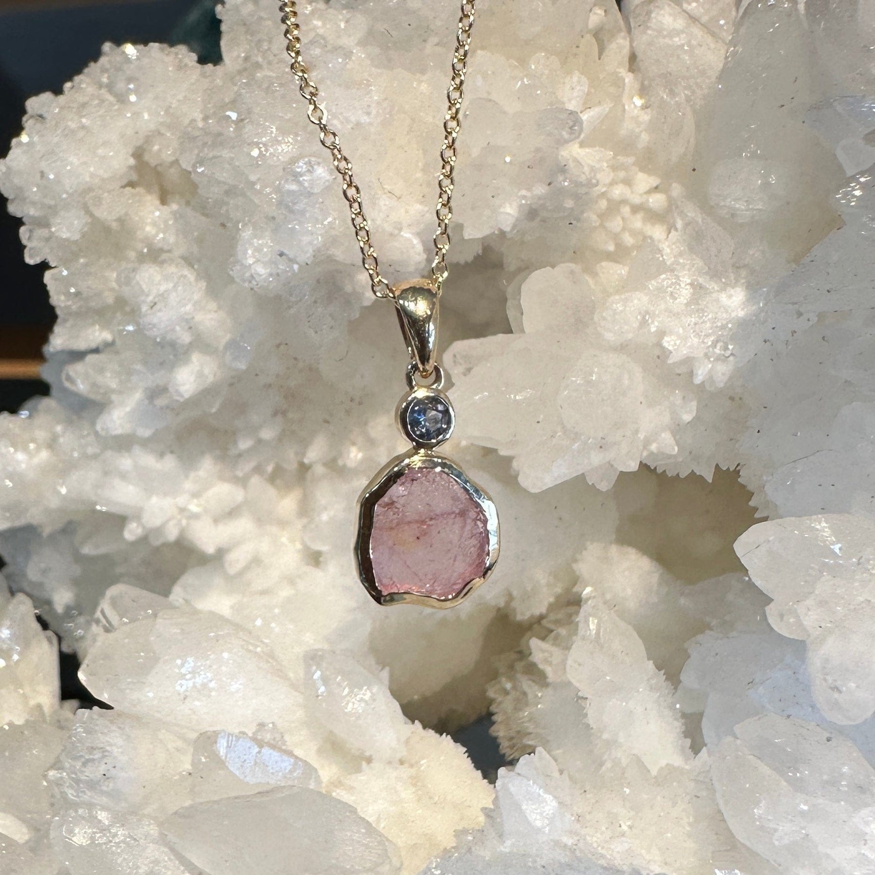 Pink raw sapphire pendant necklace on a 14k yellow gold chain.