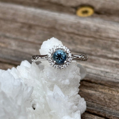 White gold halo ring with a blue Montana Sapphire