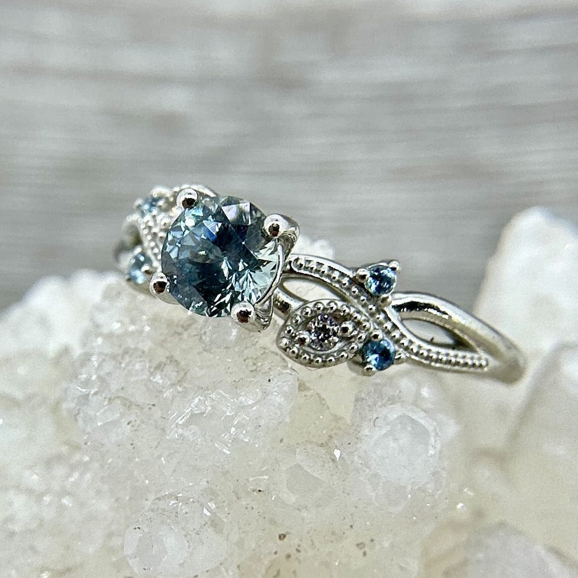 White gold ring with a blue Montana sapphire with diamonds and aquamarines