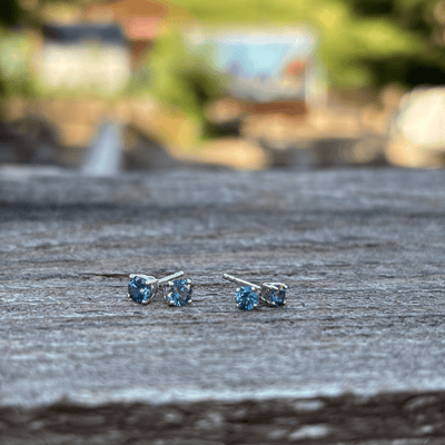 A pair of small stud earrings with round blue Montana sapphires set in sterling silver with butterfly backs.