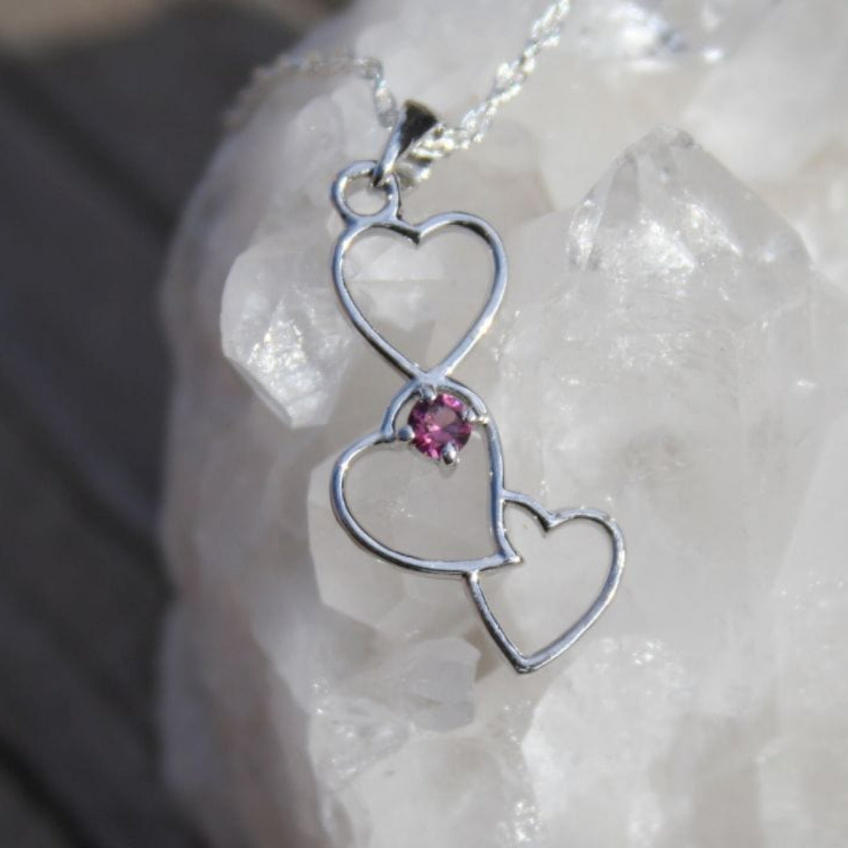 Silver interlocking heart pendant with garnet on quartz