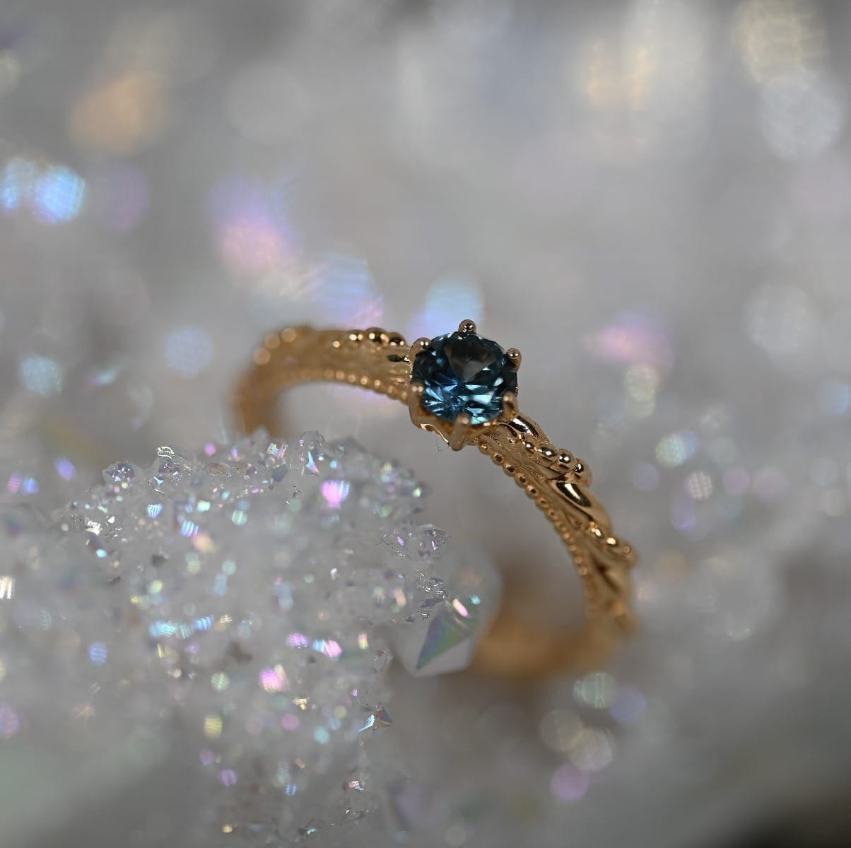 Twisted and beaded band in 14k Yellow gold holding a bright, medium blue Montana sapphire.