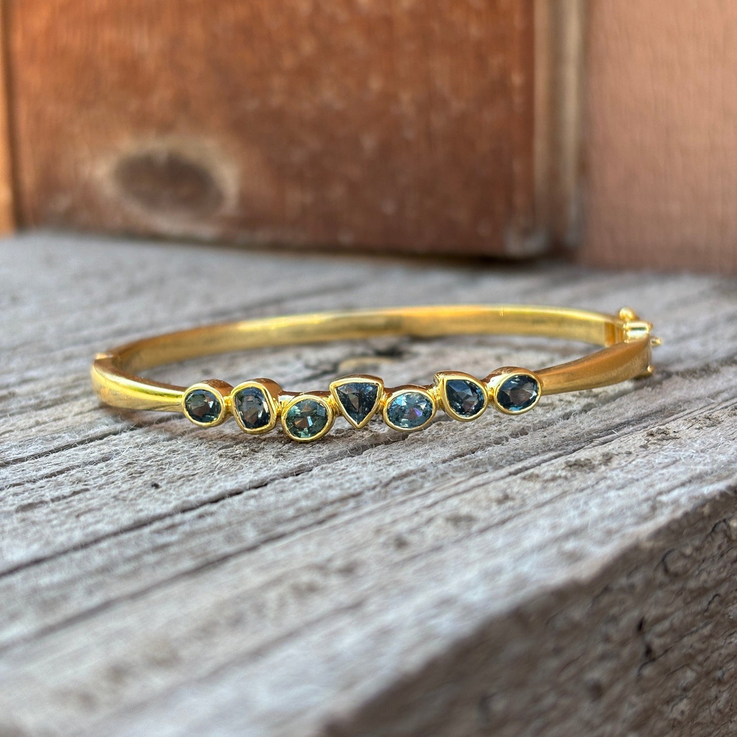 Gold bracelet with 7 blue hued sapphires
