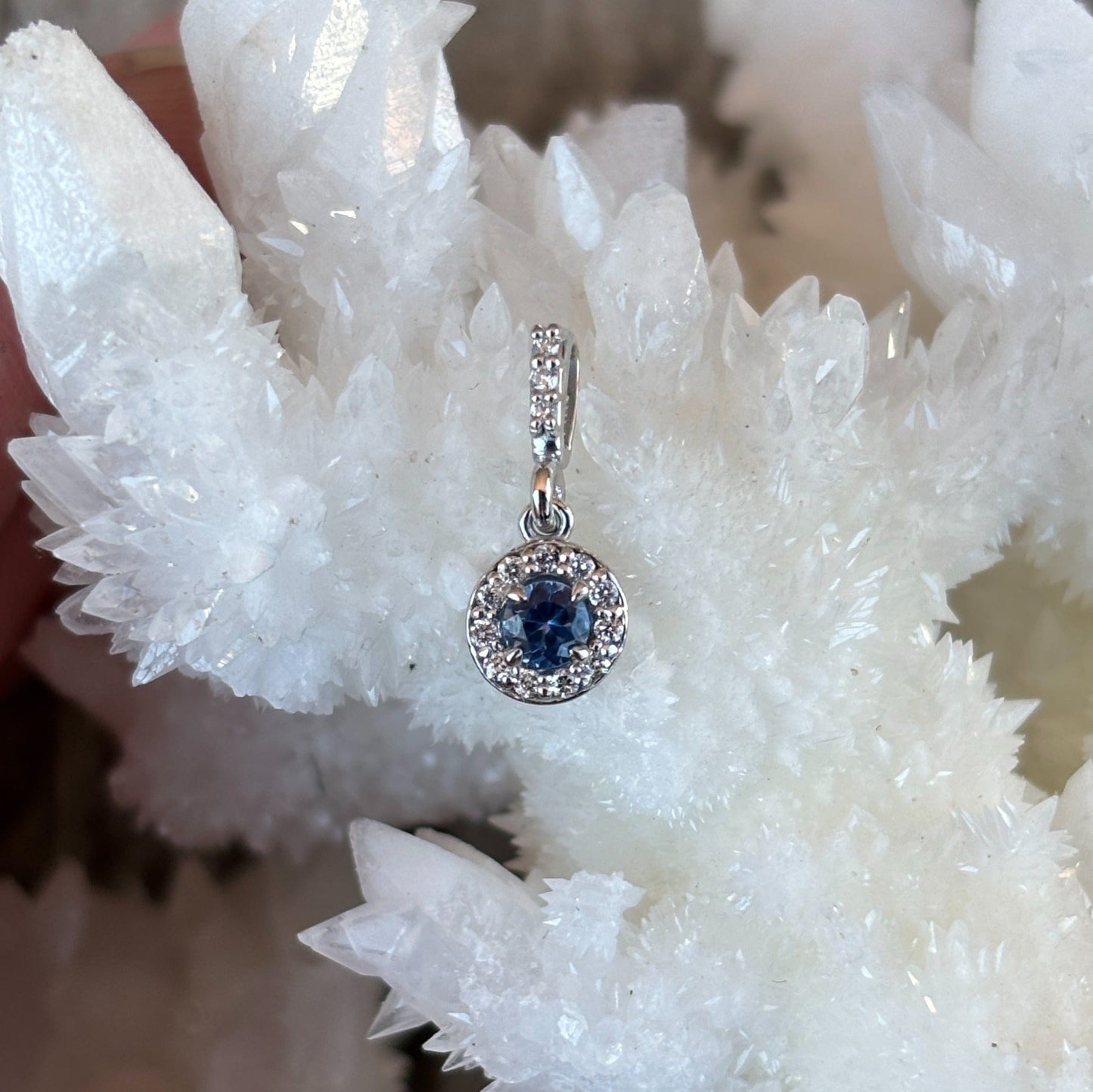 Yogo sapphire in a diamond halo pendant