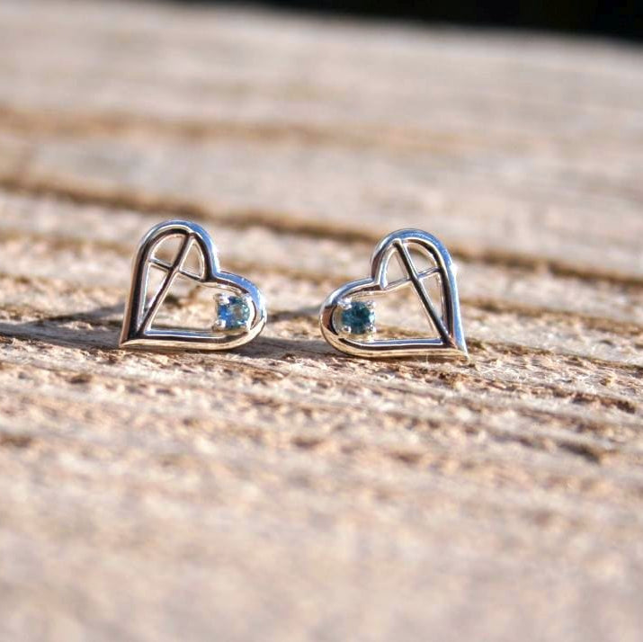 Heart-shaped silver earrings with blue sapphires and an inner cross