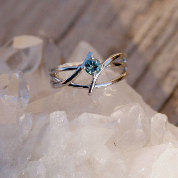 sterling silver ring with blue Montana sapphire in a an open crossed design