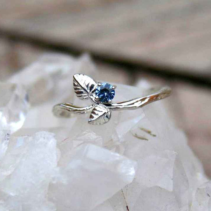 Leaf ring with blue gemstone on white crystal